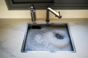 overflowing clogged sink requires professional Bright Water plumber